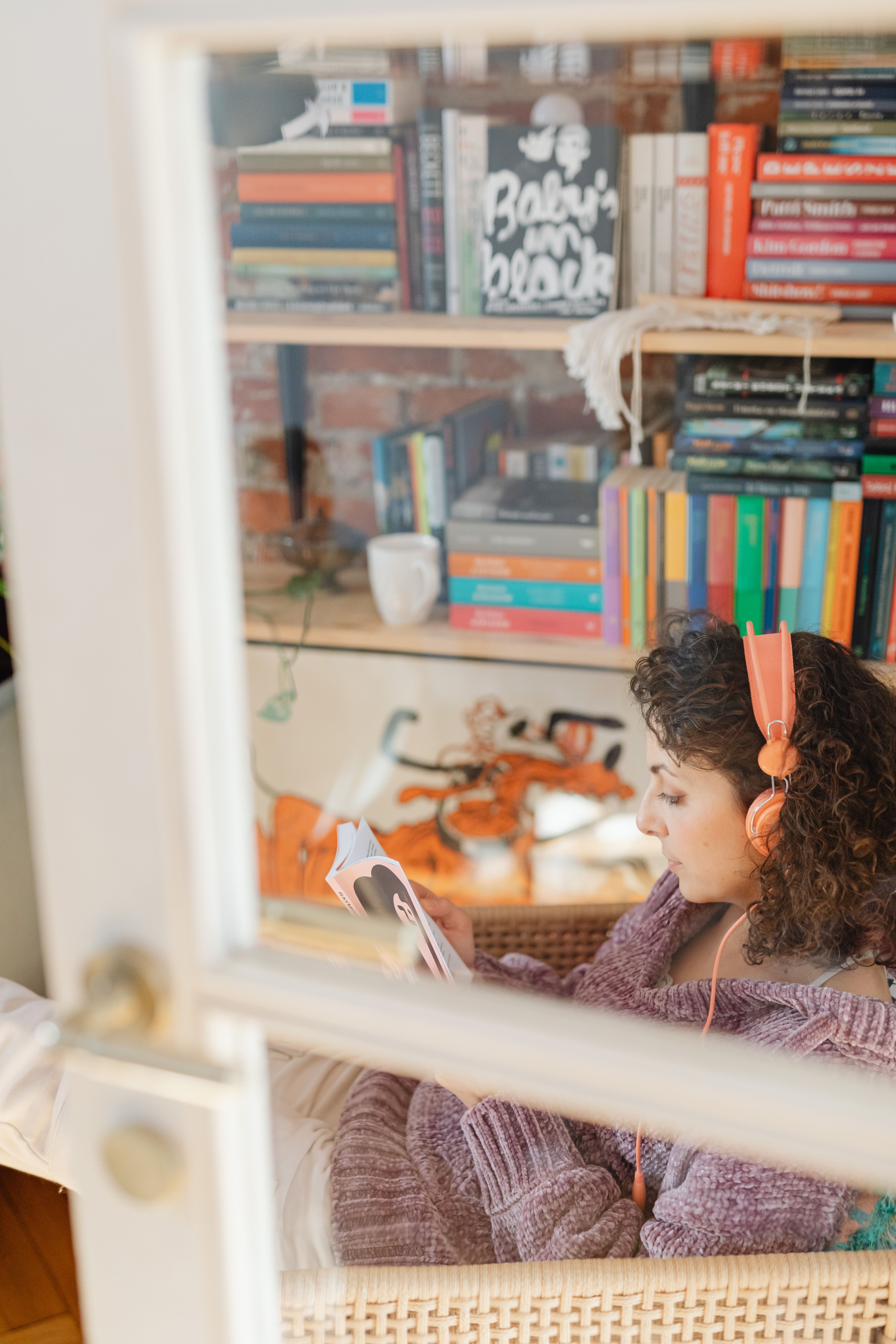 Woman listening with headphones, cozy reading session